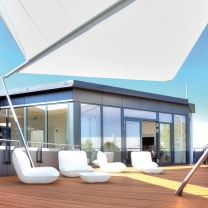 Der verglaste Innenraum grenzt an eine große Dachterrasse an, die wir mit weißen Loungesesseln möbliert haben. Das Sonnensegel spendet Schatten. Der verglaste Innenraum grenzt an eine große Dachterrasse an, die wir mit weißen Loungesesseln möbliert haben. Das Sonnensegel spendet Schatten.