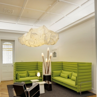 Das Sofa Alcove Highback schützt vor Blicken und ist gleichsam schalldämmend. Die mobile kleine Sessel-Bibliothek "Bookinist" von Nils Holger Moormann passt natürlich besonders gut zu einem Verlag. Lichtakzente setzen die Hängeleuchte "Clouds" (Belux) und die Steckleuchten "Pin Light" (Nils Holger Moormann).