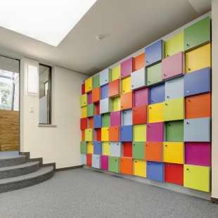 Die in die Wand eingebauten Fächer für die Wertsachen der Mitarbeiter sind ein Helten-Entwurf.